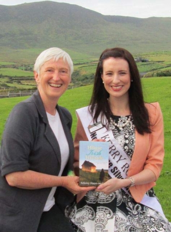 Image of Irish author Felicity Hayes-McCoy and 2013 Rose of Tralee, Gemma Kavanagh, on an Irish hillside in County Kerry, holding a copy of the author's 2013 memoir The House on an Irish Hillside